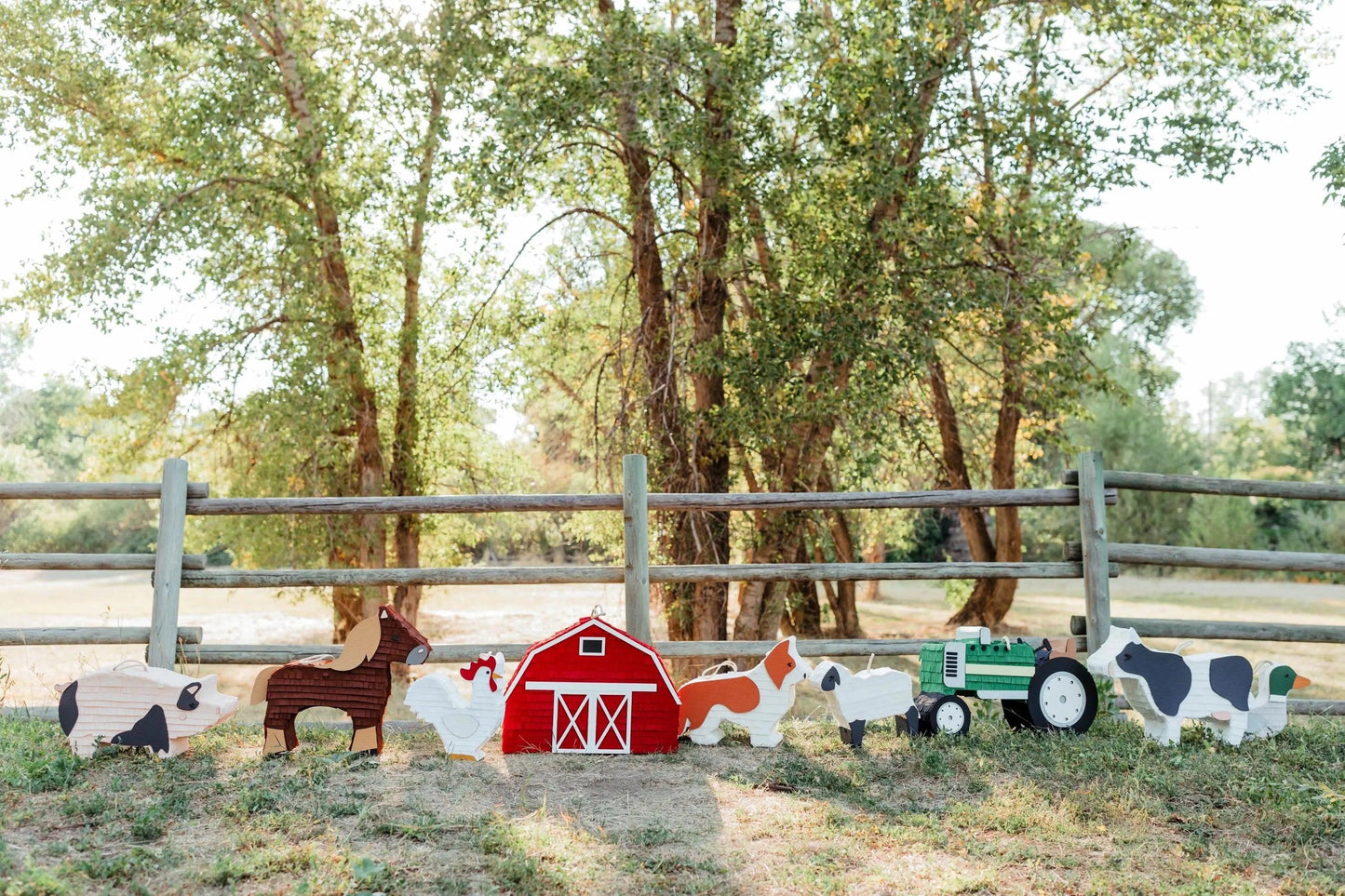 Duck piñata in farm friends set with barn and tractor decorations behind