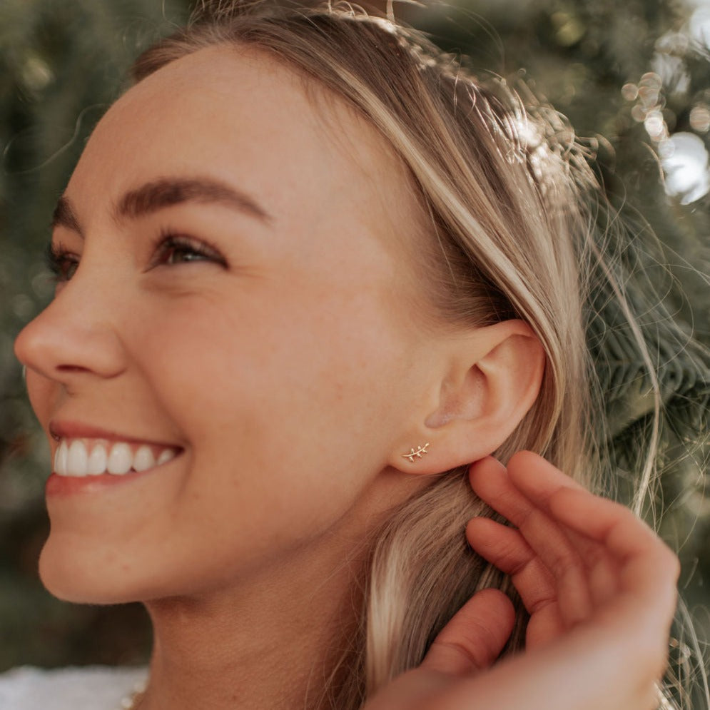 Gold leaf stud earring worn on the earlobe