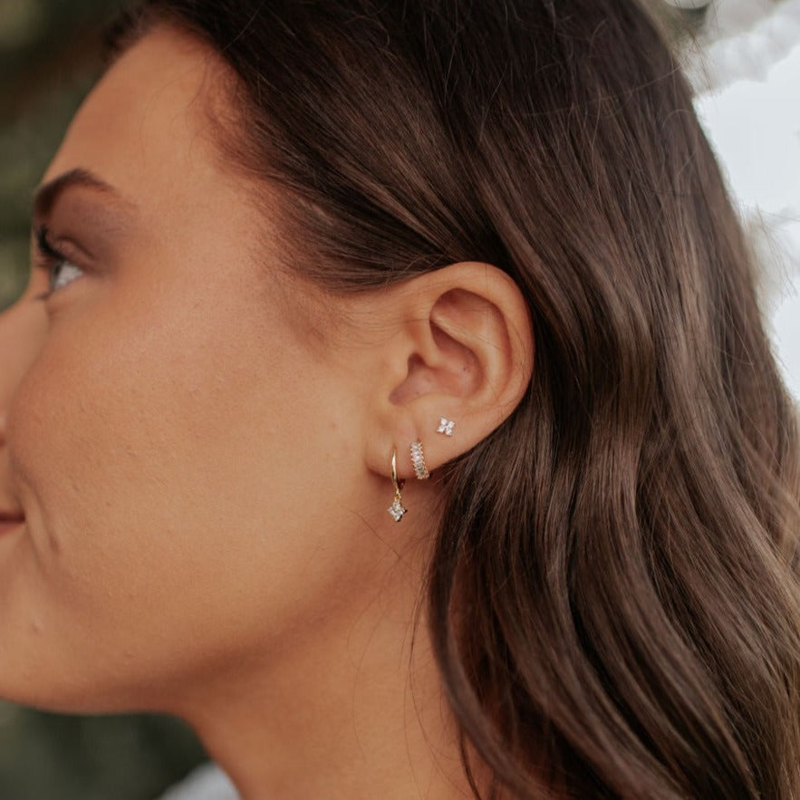 Margot flower stud earring with clear stones, worn with gold hoops