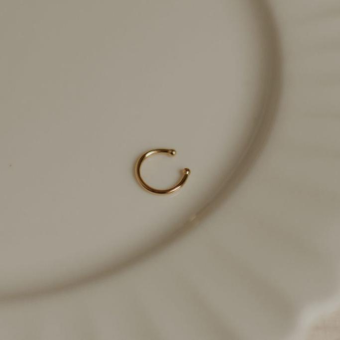 Gold ear cuff with a smooth open band and rounded ends