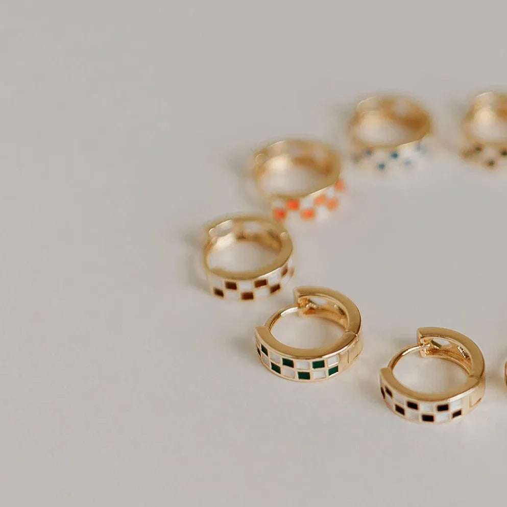 Gold hoop earrings with checkerboard enamel in green, brown, orange, and blue.