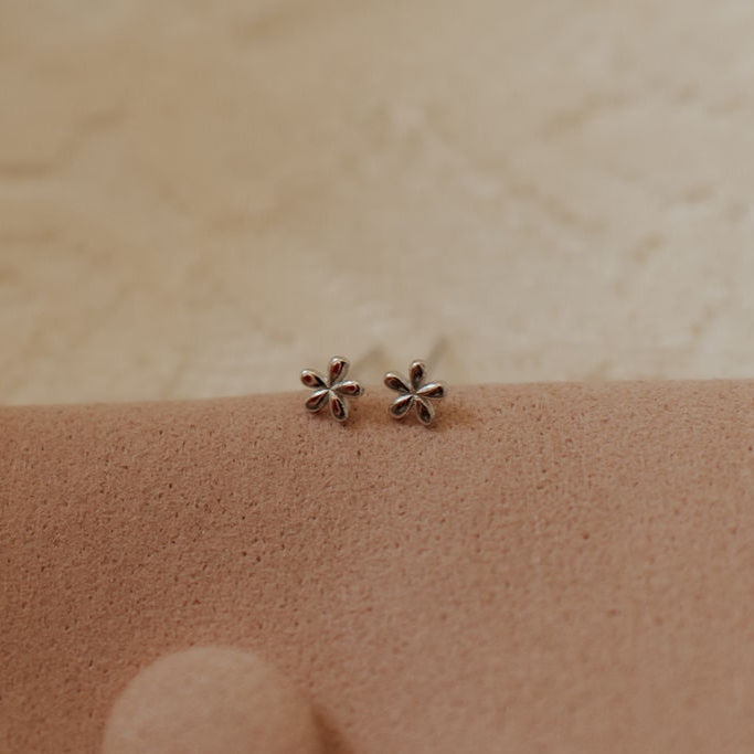 Pair of silver flower stud earrings with five rounded petals