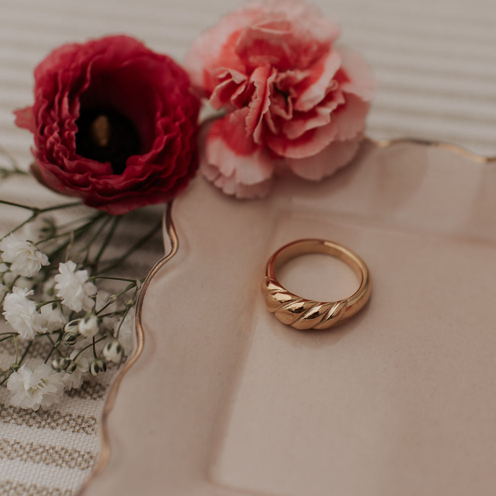 Gold ring with a smooth inner band and raised twist detail