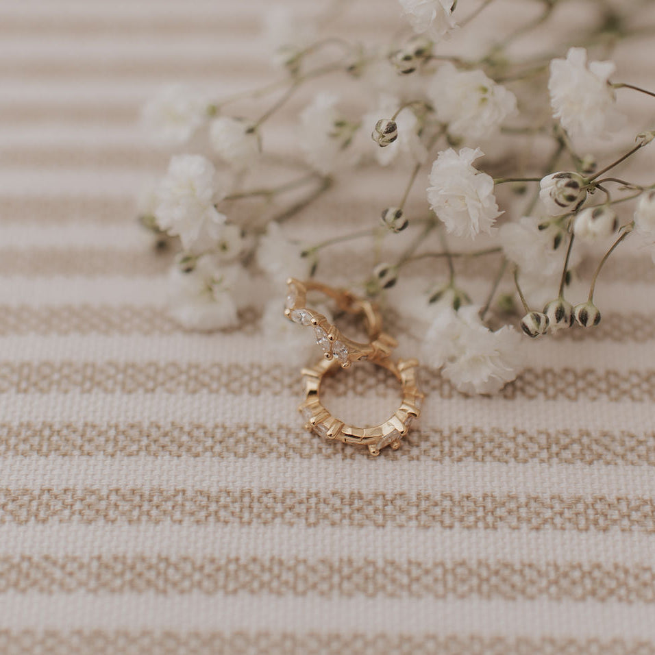 Gold hoop earring with diamond accents, shown open