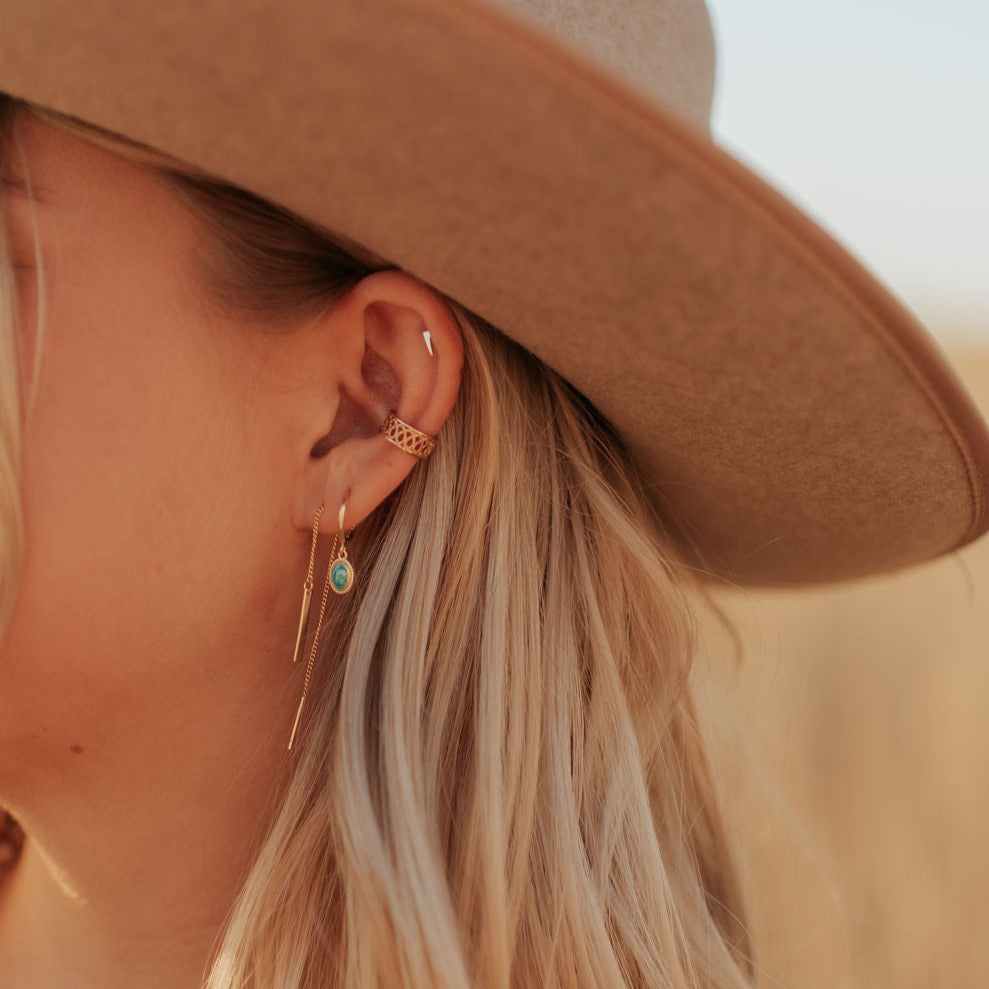 Gold bar threader earring worn with a delicate chain and slim bar drop.