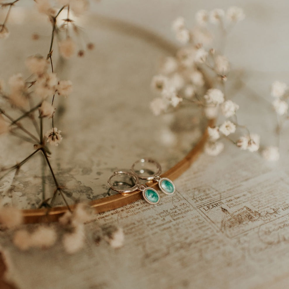 Gold hoop earrings with oval turquoise drops and detailed borders