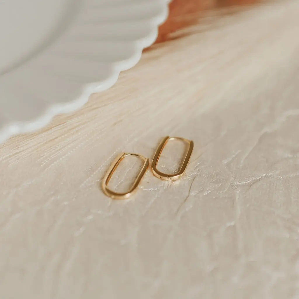 Pair of gold rectangle paperclip huggie hoop earrings with slim bands