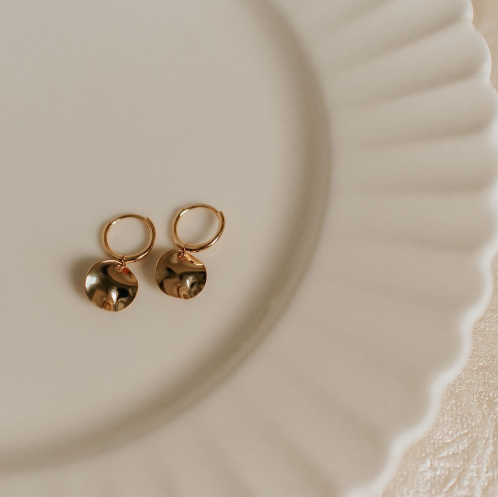 Pair of gold vermeil hoop earrings with polished hammered disc pendants