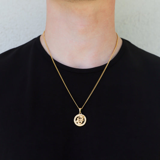 Gold dragon pendant necklace worn with a round charm on a fine chain
