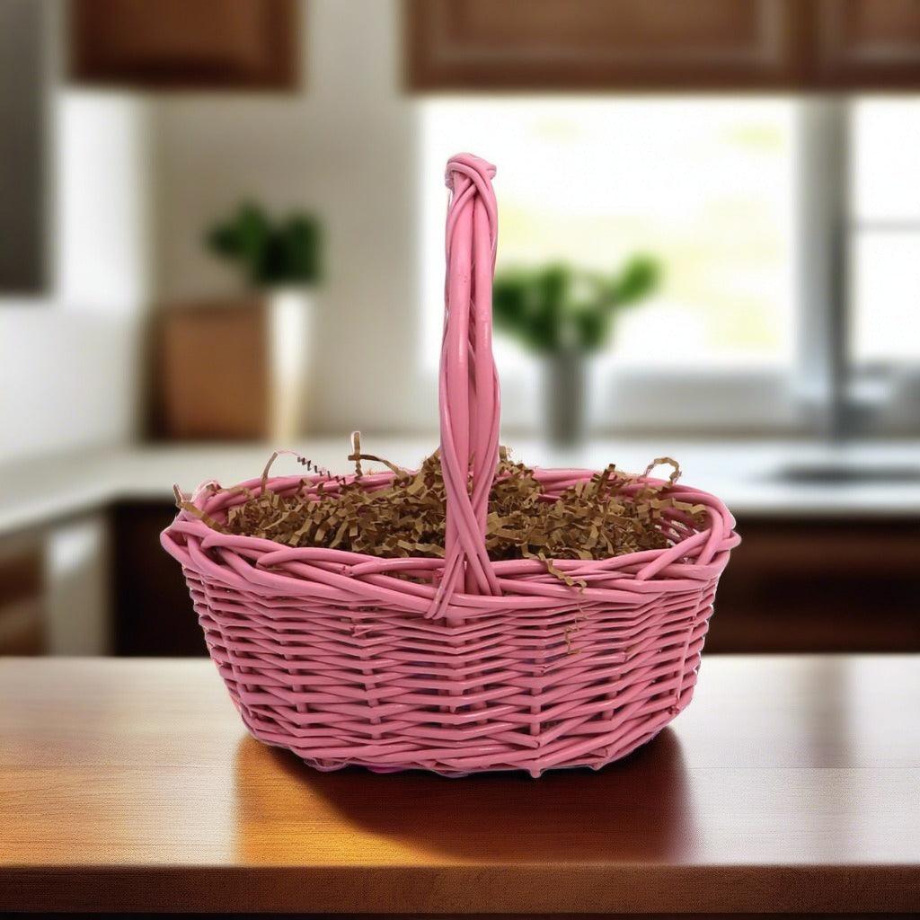 Pink wicker gift basket with long handle and decorative filler