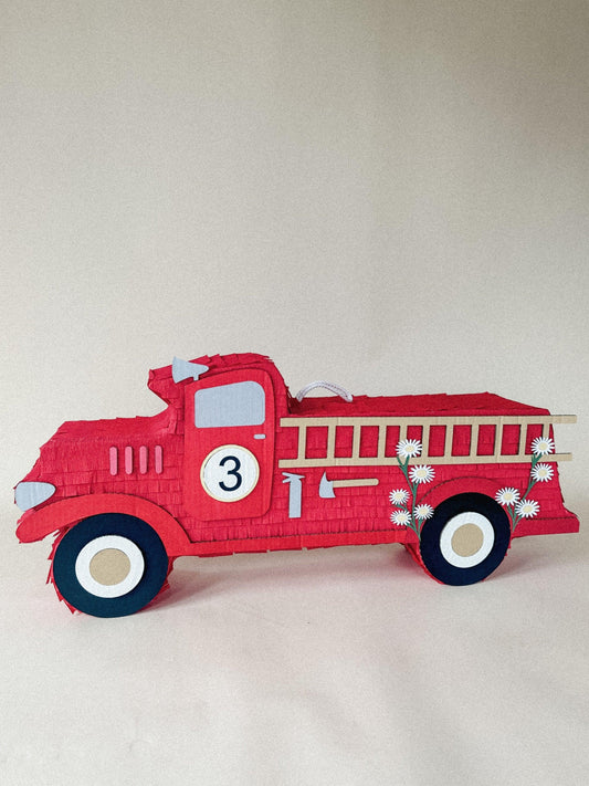 Red firefighter fire truck piñata, side view with “3” badge and daisy accents