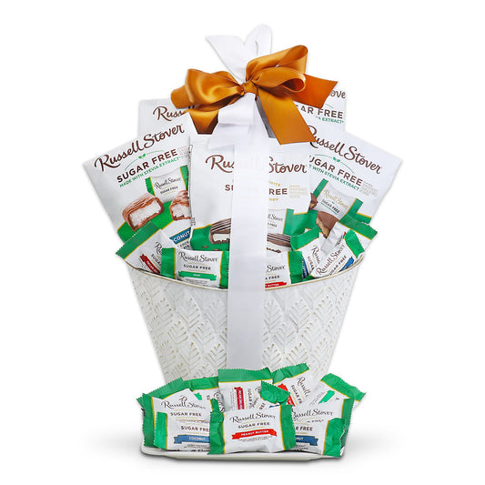 White gift basket filled with green-wrapped sugar-free chocolates, tied with orange bow.
