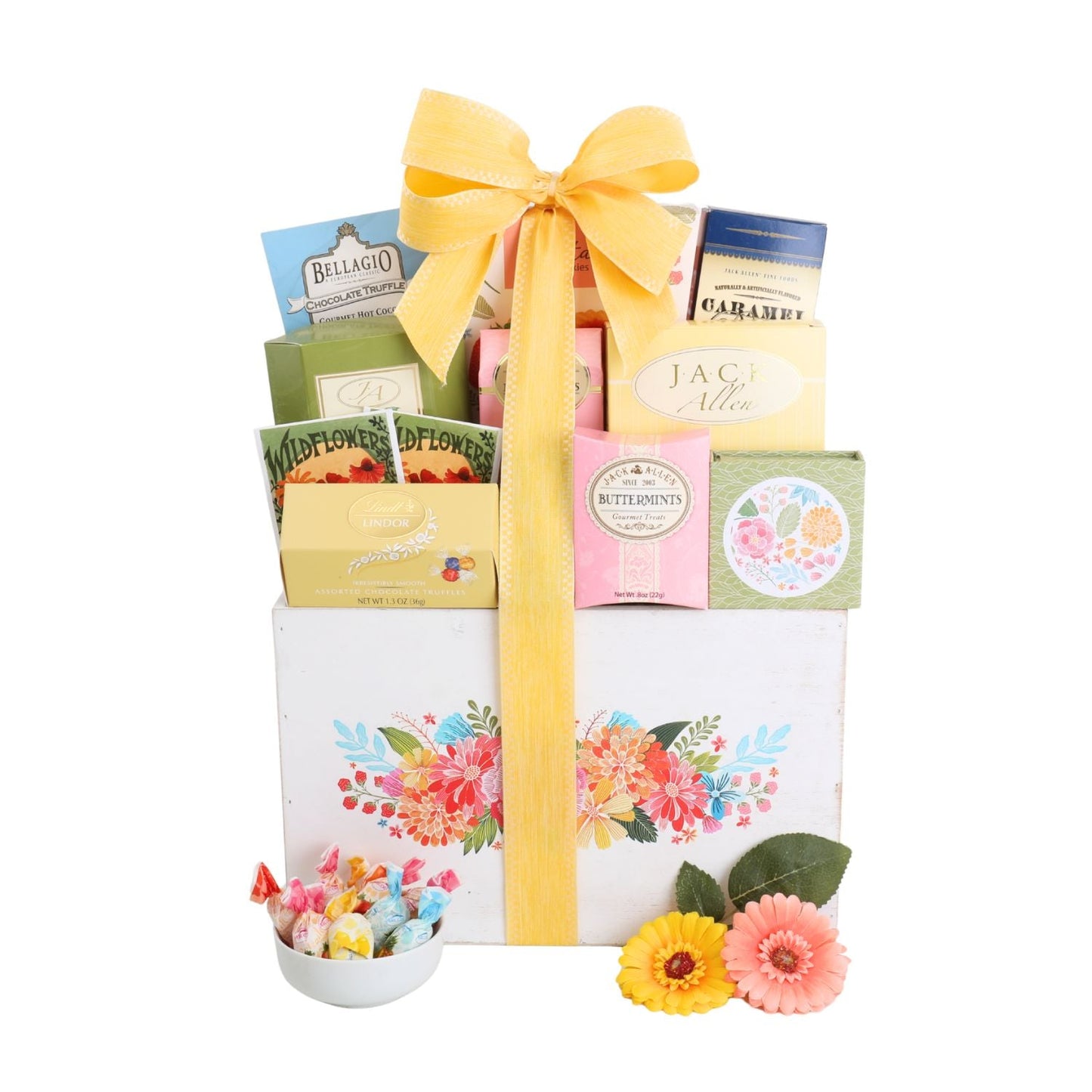Sweet gift basket with white floral panel, yellow bow, assortment of candy boxes