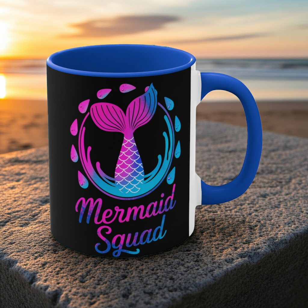 Blue-handled black ceramic mug with mermaid squad graphic, pink and teal scales.