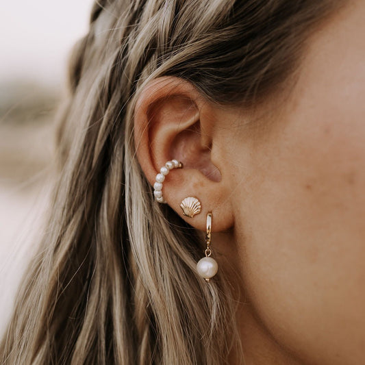 Bondi Pearl gold hoop earring with a white pearl drop, worn with other pearl earrings