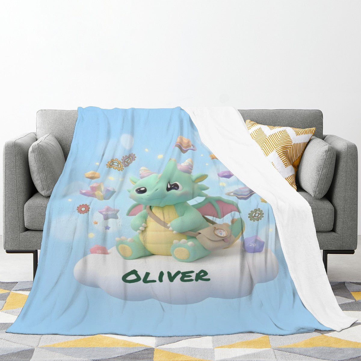 Light blue blanket with green dragon and Oliver cloud design, laid over couch