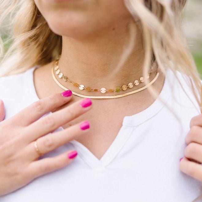 Gold filled coin necklace layered with a slim gold collar necklace.