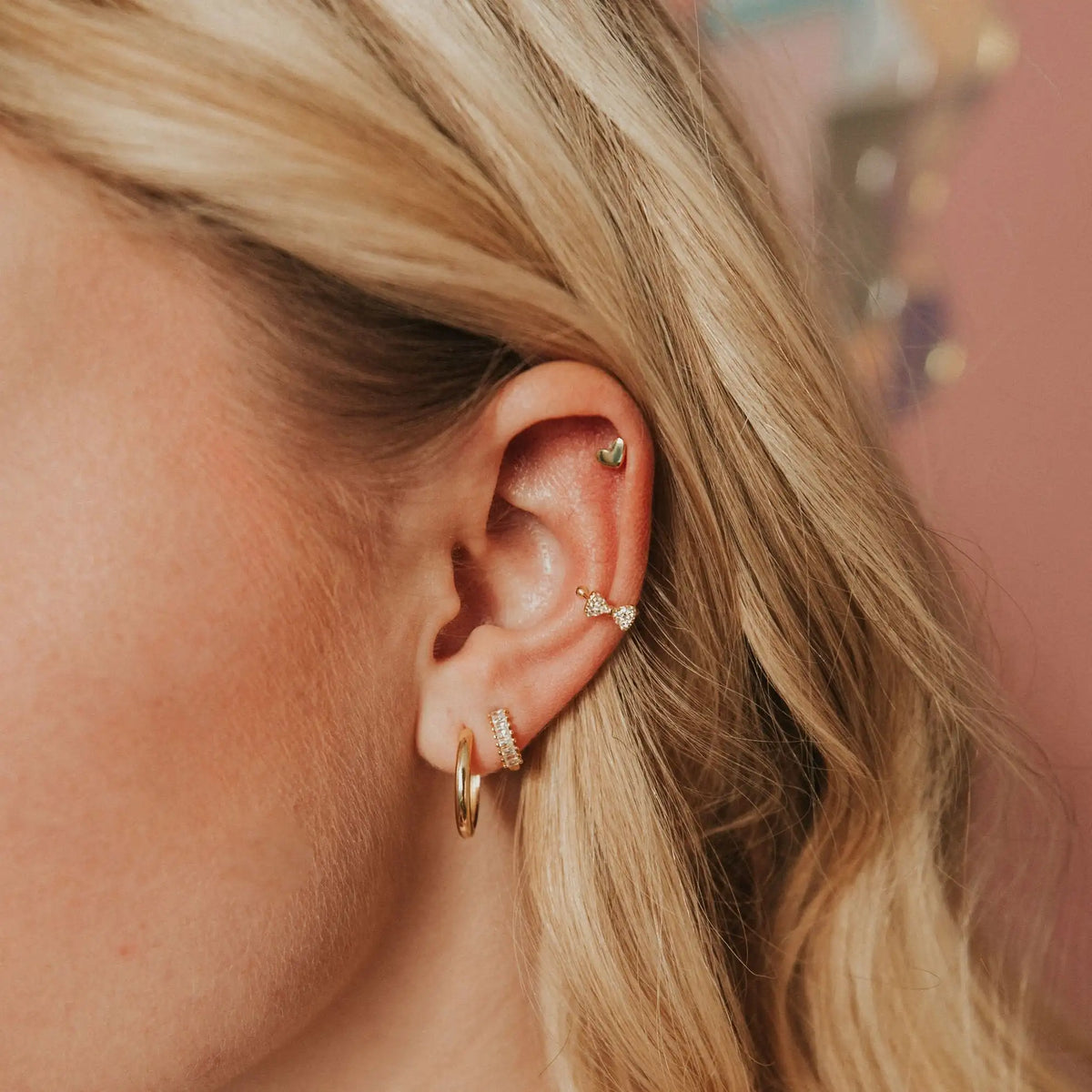 Tiny gold heart stud worn on the upper ear
