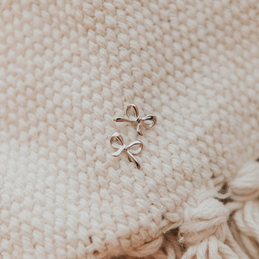 Pair of silver bow-shaped stud earrings with sculpted loops
