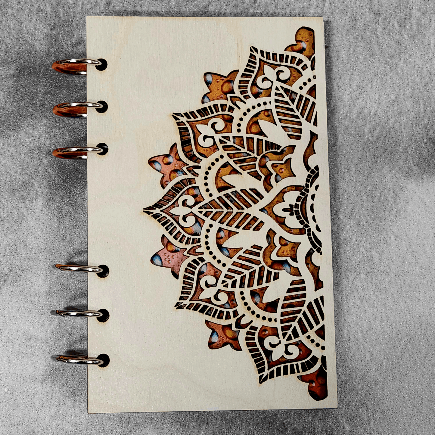 A6 mandala notebook close-up with metal rings and brown ornamental pattern on cover
