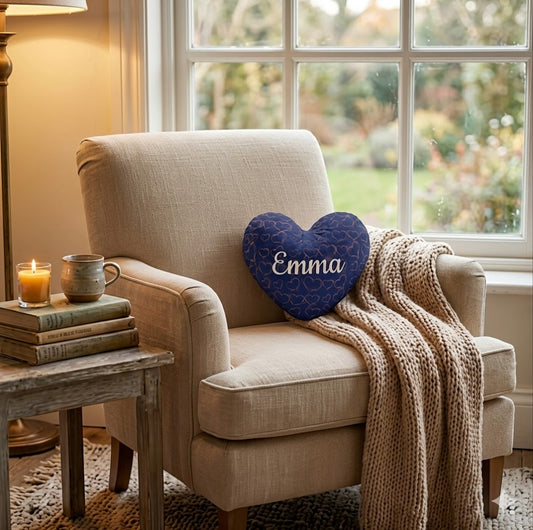 Navy heart-shaped name pillow with 'Emma' on an armchair seat