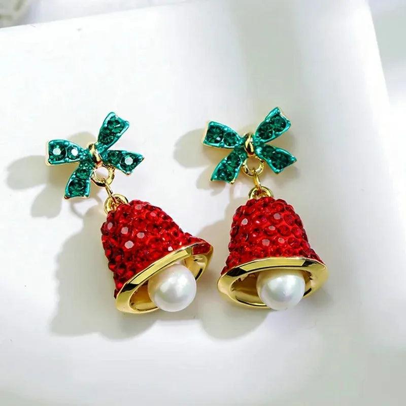 Drop earrings with green bow, red glitter bell charms, and white pearl drops on gold hooks