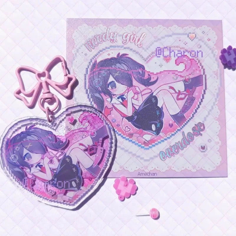 Acrylic heart keychains with pink and blue bows beside character heart charms
