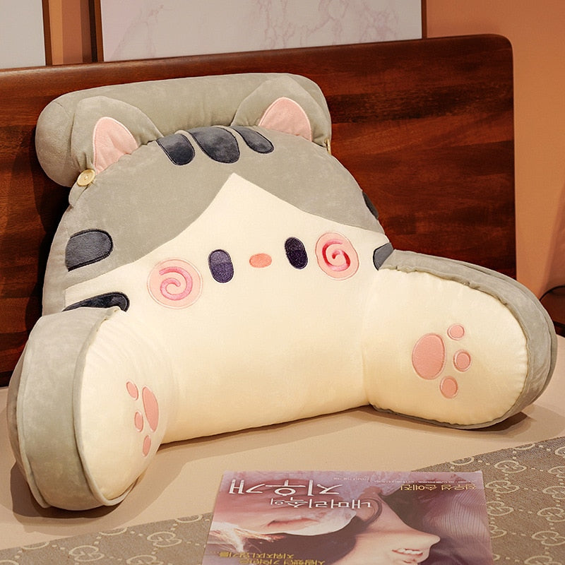 Grey cat reading pillow with cream belly, spiral eyes, and paw-print accents