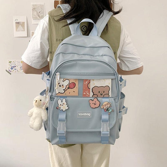 Light blue mini backpack with front zip pocket, cartoon panel, and adjustable shoulder straps