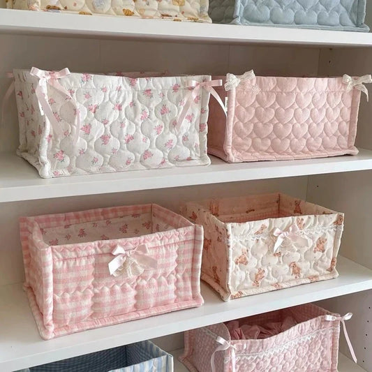 Decorative fabric storage boxes in pastel prints, pink and white with tied bows