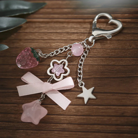 Silver keychain with pink beads, clover charm, ribbon bow and star dangles