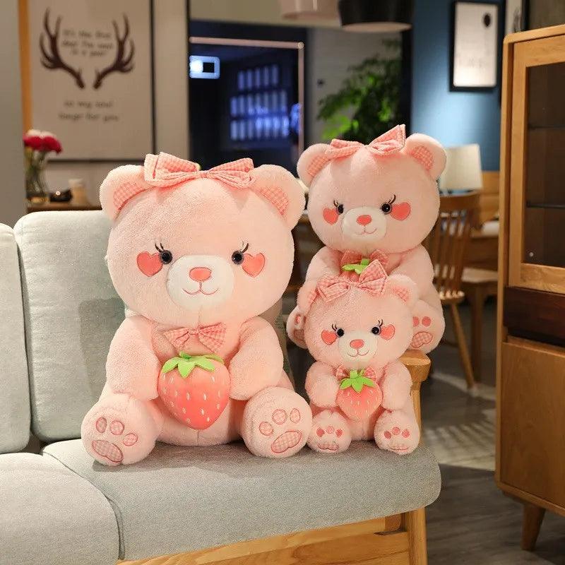 Two pink strawberry bear plushes with bows and strawberry accessories, seated side by side