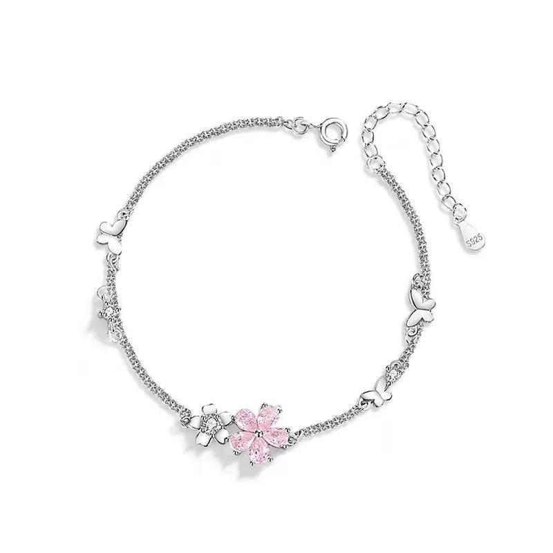 Sterling silver bracelet with pink cherry blossom charm and heart bead accents