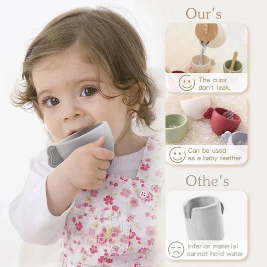 Child playing with wooden tea set cups and teapot, holding a gray cup
