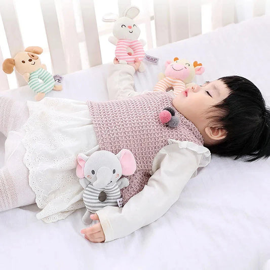 Baby hand holding a striped animal plush ring rattle toy with round rattle