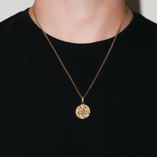 Gold coin pendant necklace worn on chest over black crewneck shirt