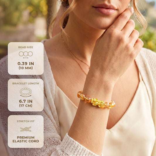 Amber citrine bead bracelet with gold dragon charm, worn on wrist