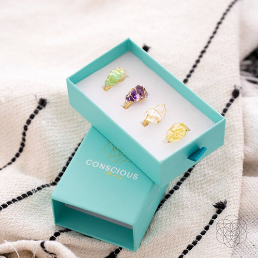 Gold wire gemstone anti-stress rings in teal display box, four colored stones