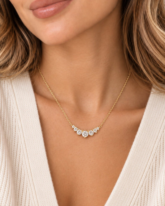 Gold-tone diamond cluster necklace with a center pendant of sparkling stones