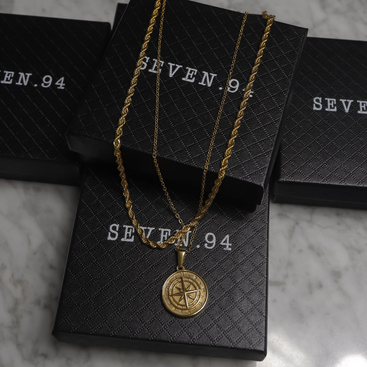 Gold compass pendant necklace set in black gift bags