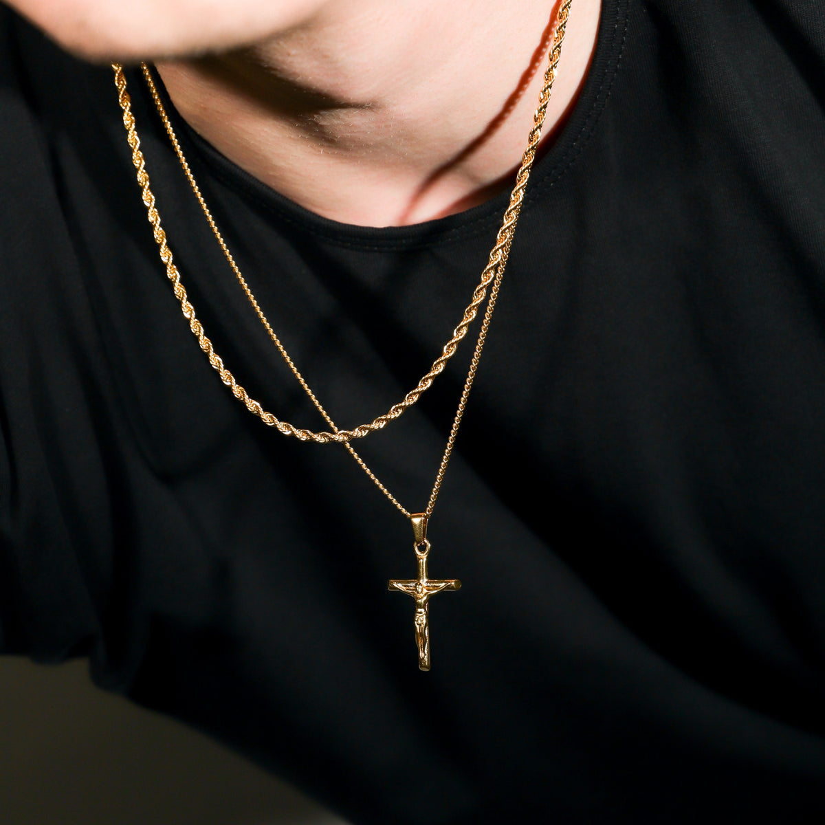 Gold crucifix pendant necklace set with two rope chains and cross pendants, close-up