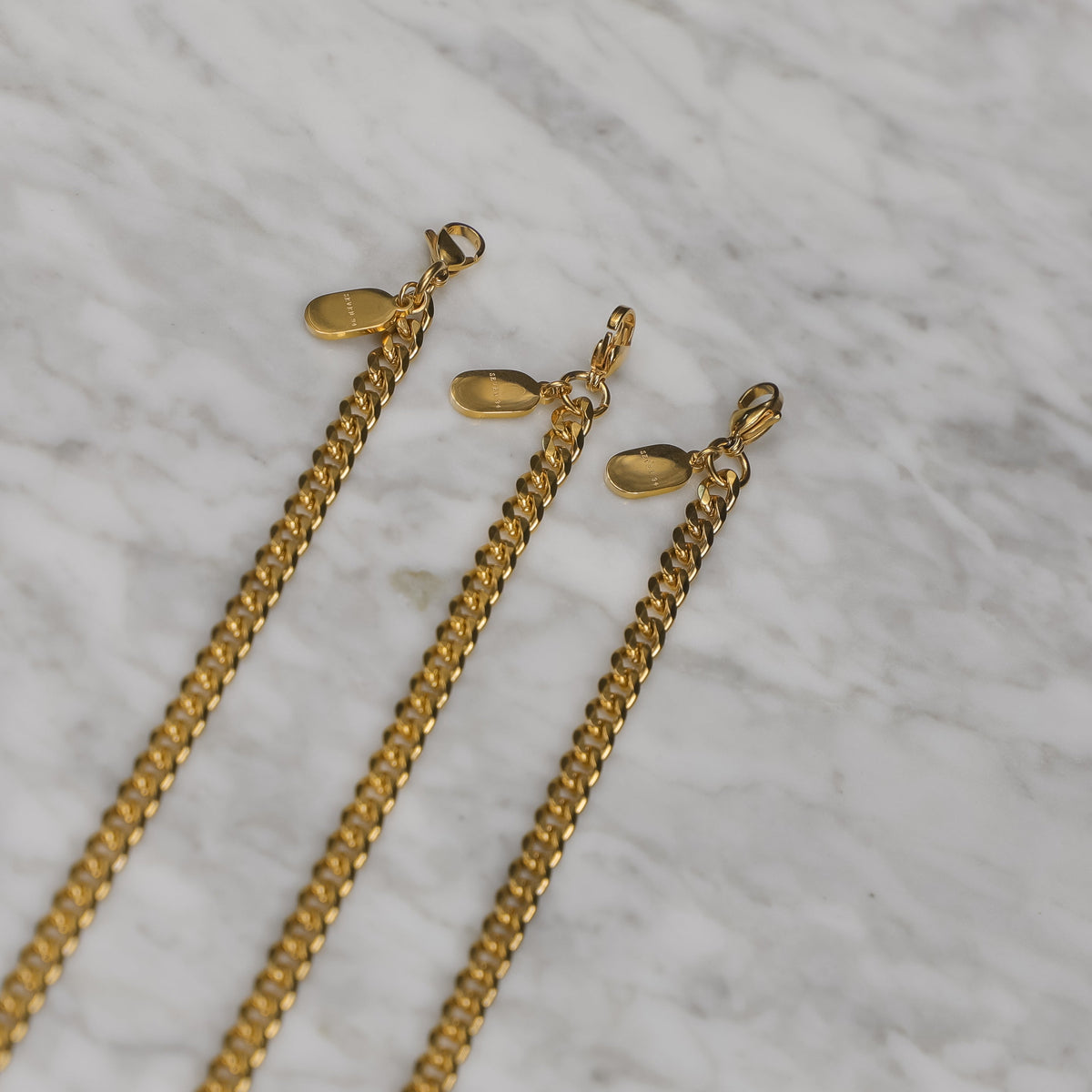 Set of gold Cuban link bracelet chains with clasp ends