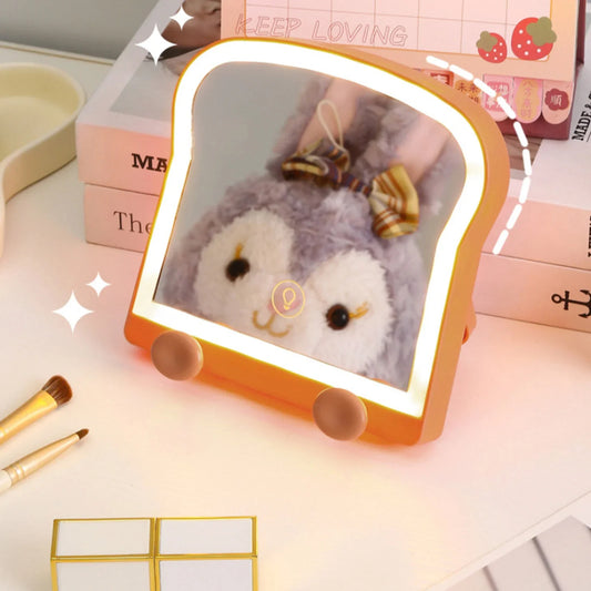 Toast-shaped LED makeup mirror with gray plush bear graphic, lit border and phone stand pegs