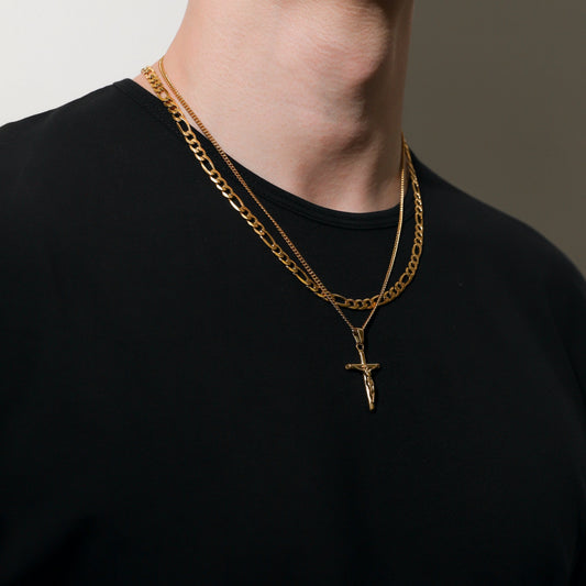 Double-layer gold figaro chains with crucifix pendant, worn on black shirt