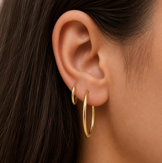 Gold-tone hoop earrings on ear, seamless round profile