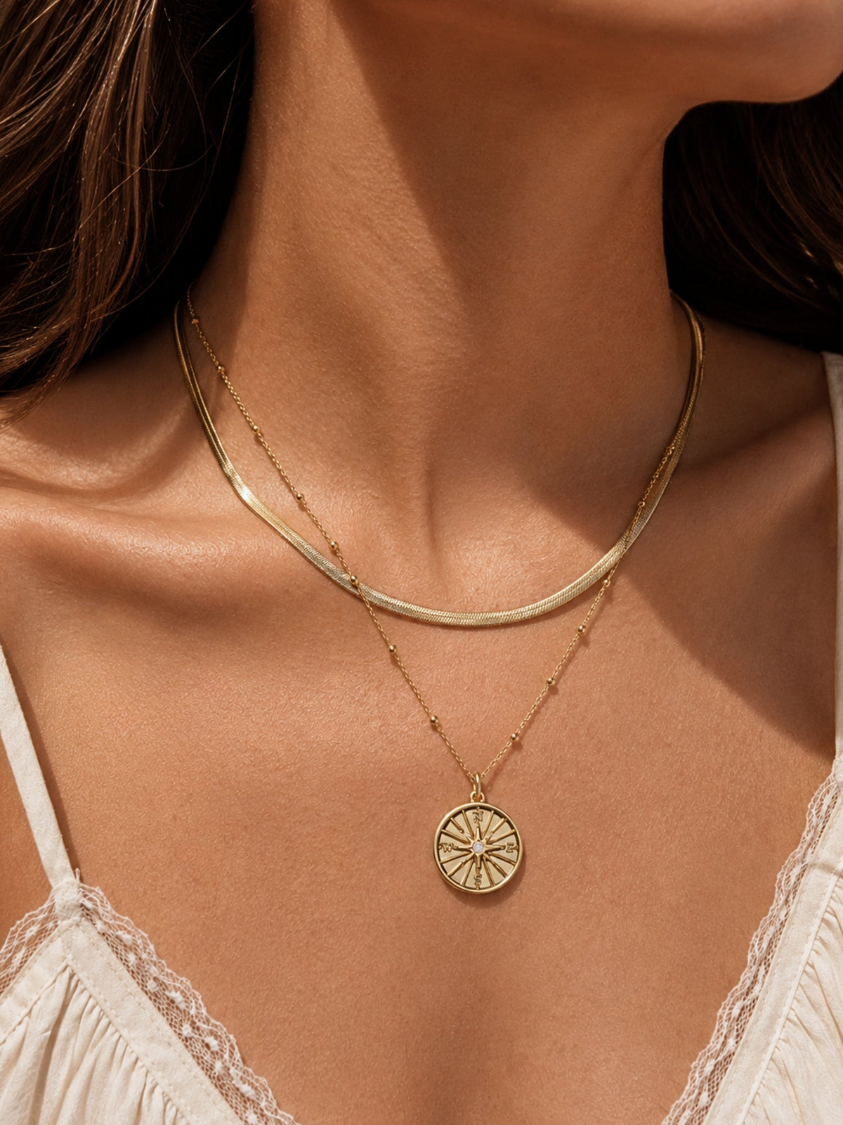 Gold compass pendant necklace with thin layered chain and round medallion