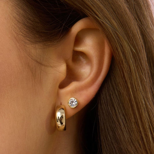 Gold dome hoop earring on ear, smooth rounded design with hinge post at back