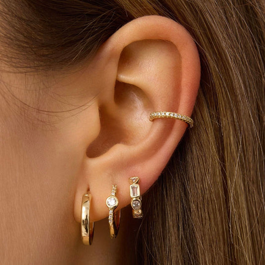 Gold-tone hoop earring with small crystal-studded vertical drops and a hinge clasp