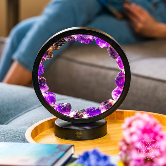 Amethyst crystal halo lamp with purple glowing ring and black base on table