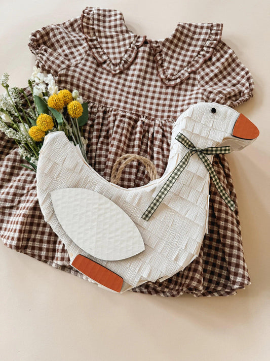 White goose piñata with plaid bow and oval wing fabric panels